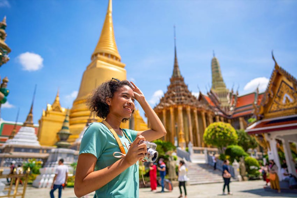 African traveller with a camera at Wat Phra Kaew, the Grand Palace, Bangkok, Thailand